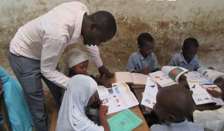 Digo Mother Tongue Education Officer with students